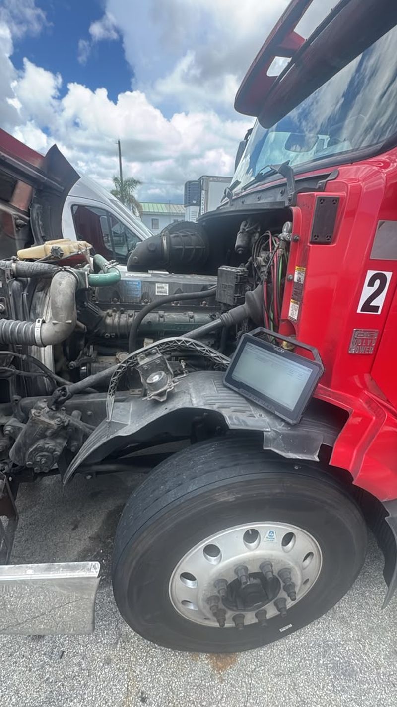 Diagnóstico de motor Volvo D13 con tablet en un camión con el capó abierto